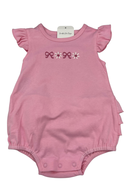 Nannette's Online Designs pink infant bubble romper with ruffle sleeves, bow and flower embroidery, and bottom snaps.
