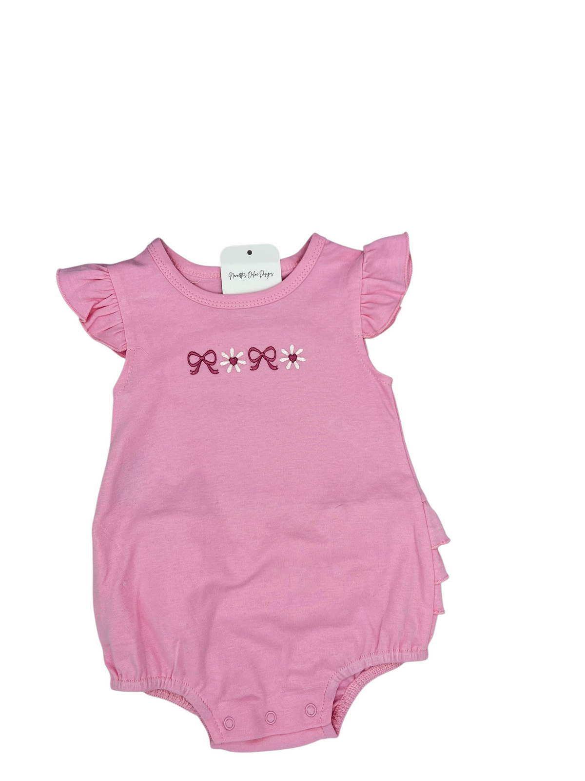 Nannette's Online Designs pink infant bubble romper with ruffle sleeves and embroidered bow and flower detail.