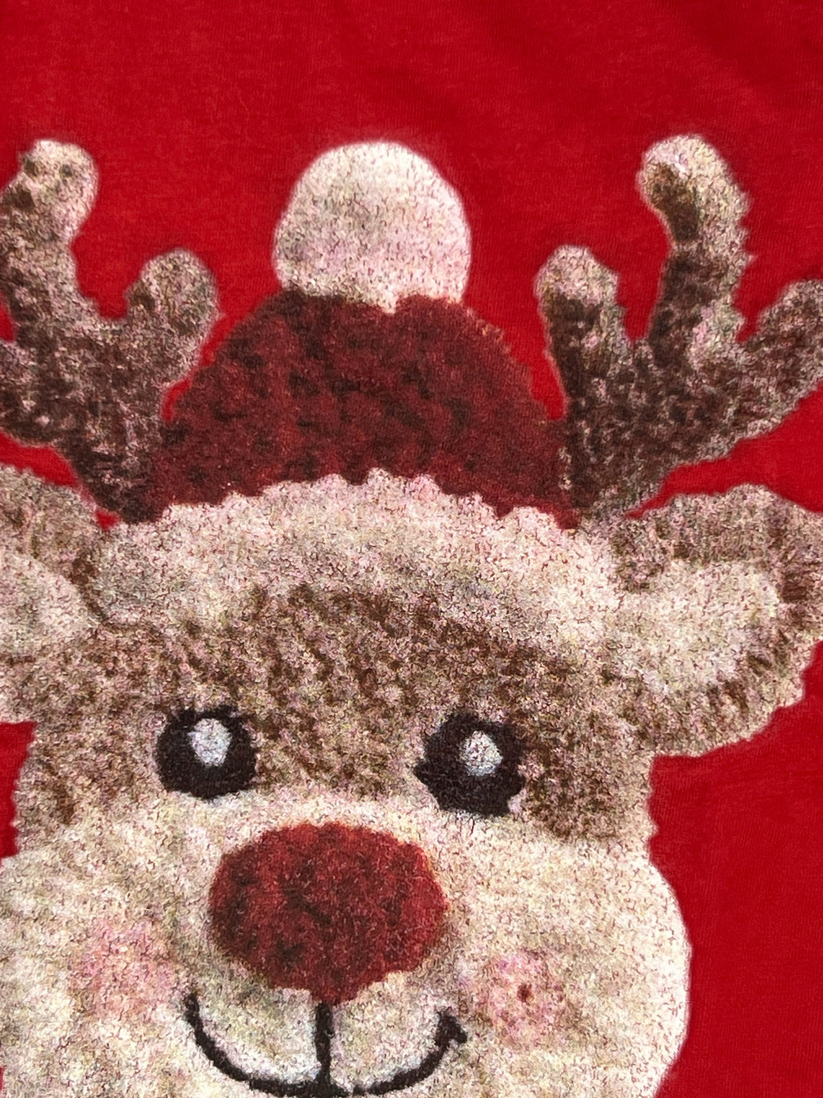 Nannette's Online Designs red holiday t-shirt featuring a textured reindeer graphic wearing a festive Santa hat