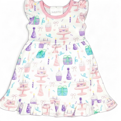 Nannette's Online Designs toddler birthday dress with pastel cake, cupcake, and gift print, flutter sleeves, and ruffles