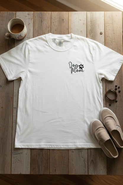 Nannette's Online Designs white cotton t-shirt featuring black embroidered Dog Mom text and a paw print on the chest.
